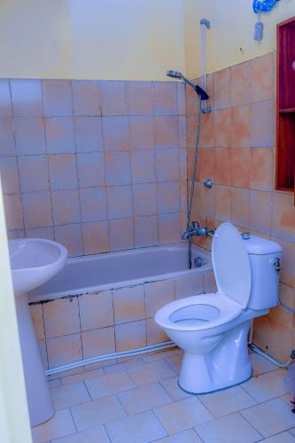 a bathroom with a toilet and a sink and a tub at Au cœur de Bonanjo in Douala