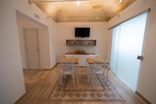 a living room with a table and chairs and a tv at Butiko in Castelluzzo
