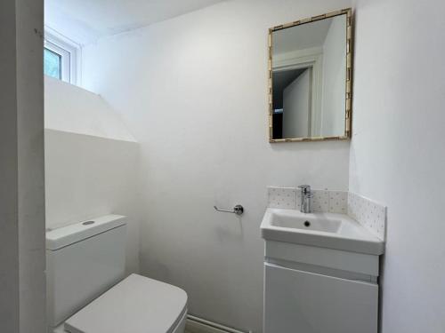 ein weißes Bad mit einem WC und einem Waschbecken in der Unterkunft Lovely 4bed property, London 8min to Oxford Street in London