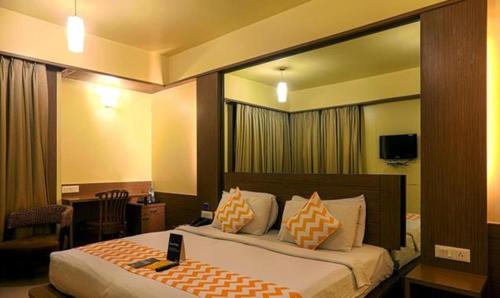 a bedroom with a bed with a large mirror at FabHotel Prime Ivy Studio in Pune