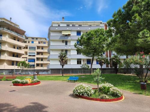 - un grand bâtiment blanc avec un parc en face dans l'établissement Casetta Lungomare, à Pescara