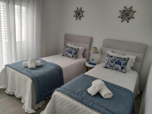 a bedroom with two beds with towels on them at Apartamento Estrela do Mar in Nazaré