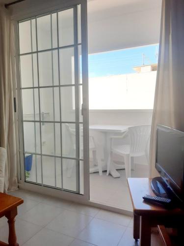 a sliding glass door leading to a patio with a table at Apartamentos Bellavista Gomera in Playa de Santiago
