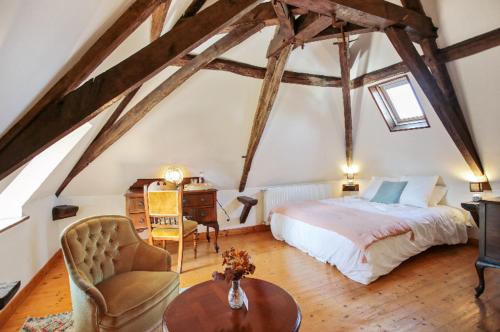a bedroom with a bed and a desk in a attic at Villa Mamba in Saint-Porchaire