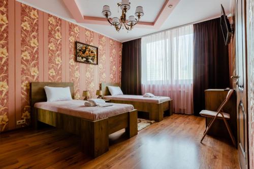 a bedroom with two beds and a chandelier at Poznyakoff Aparthotel in Kyiv