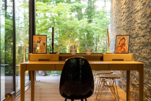 a wooden desk with a chair in front of a window at La Maison Karuizawa in Karuizawa