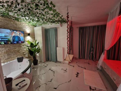a bathroom with a bath tub and a tv on the wall at XMX Jacuzzi and Baldachin Studio in Bucharest
