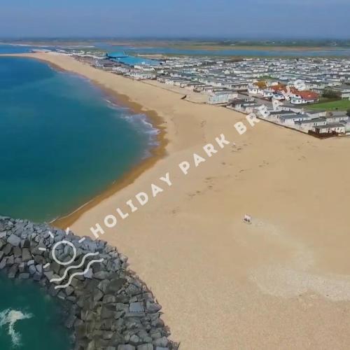 a view of a beach with a town in the background at Stylish Family Caravan Retreat - Seal Bay, Selsey in Chichester