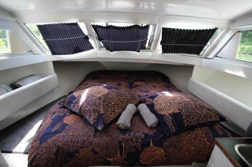 una cama en la parte trasera de una caravana en Nuit à quai sur notre vedette! en Meilhan-sur-Garonne