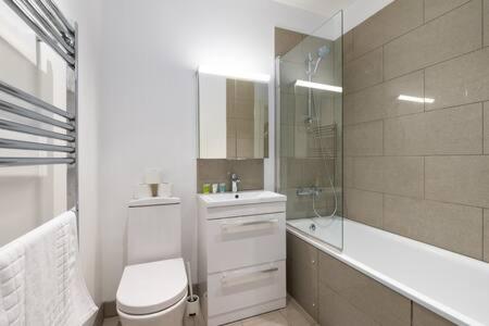 ein Bad mit einem WC, einem Waschbecken und einer Dusche in der Unterkunft Trendy East London Flat SH11 in London