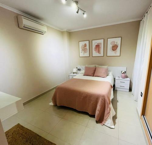 sypialnia z łóżkiem z różowymi poduszkami w obiekcie Centro-Torre del mar - HOME RENT MALAGA w mieście Torre del Mar