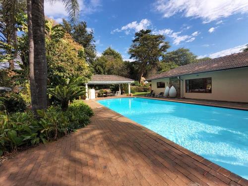 una piscina di fronte a una casa di 2 bedroom cottage with Sandton skyline vista a Johannesburg