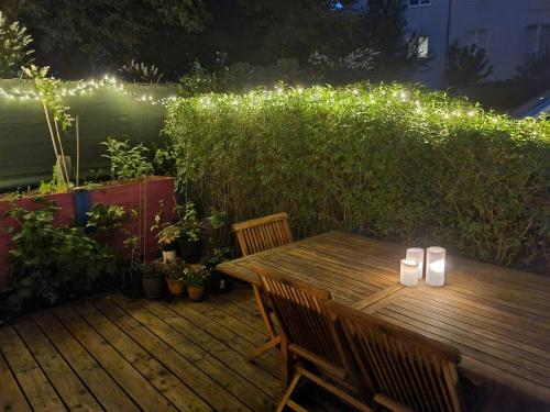 a wooden table and chairs on a deck with lights at Helenas place in Berlin