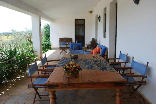 una mesa de madera con sillas azules y una mesa con flores en Herdade do Monte Outeiro - Turismo Rural, en Venda