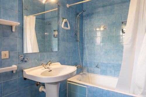 een blauw betegelde badkamer met een wastafel en een bad bij Gran Sol Family 4 in Felanitx