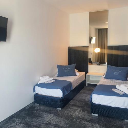 a hotel room with two beds and a mirror at Mirage Beach Spa Hotel in Eforie Nord