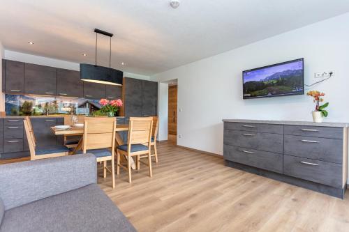 a kitchen and dining room with a table and chairs at Kaiser Apart Walchsee in Walchsee