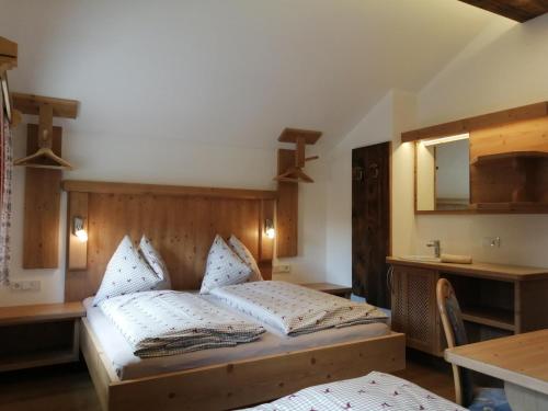 um quarto com uma cama, uma mesa e um espelho em Hintergugg em Mittersill
