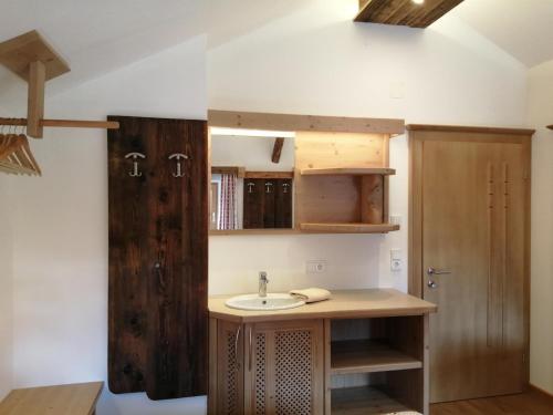 uma casa de banho com um lavatório e um armário de madeira em Hintergugg em Mittersill
