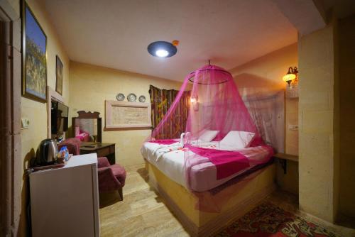 una camera con letto e zanzariera rosa di Lucky Luke Stone House a Göreme