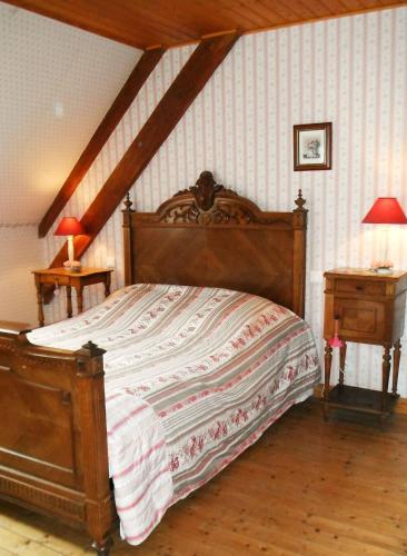 - une chambre avec un grand lit en bois et 2 tables dans l'établissement Le grand large 1, à Coulogne