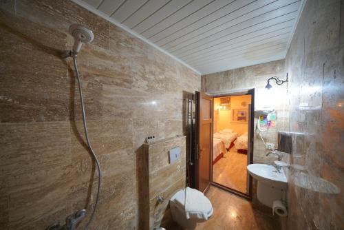 y baño con ducha, lavabo y aseo. en Lucky Luke Stone House en Göreme