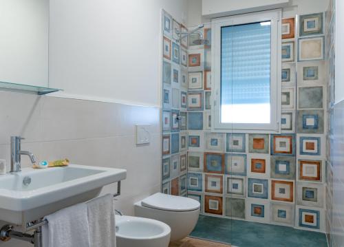 a bathroom with a sink and a toilet and a window at Villa Mare Pineto in Pineto