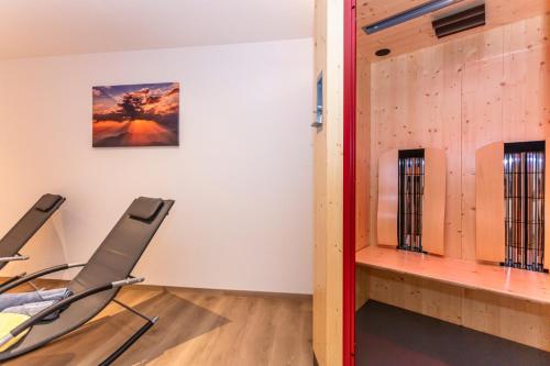 a room with two chairs in front of a wall at Kaiser Apart Walchsee in Walchsee
