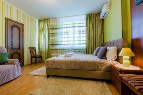 a bedroom with a large bed and a window at Poznyakoff Aparthotel in Kyiv