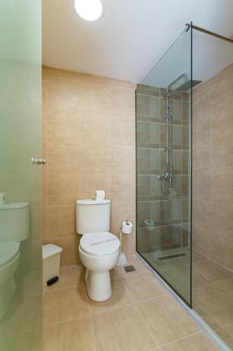 a bathroom with a toilet and a glass shower at Triton Hotel in Malia