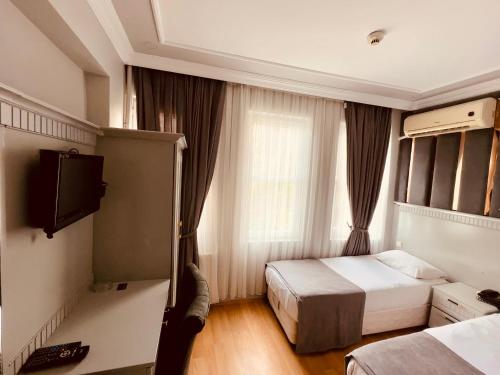 een hotelkamer met 2 bedden en een televisie bij Grand Hurriyet Hotel in Istanbul