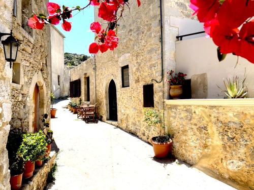 an alley with flowers on the side of a building at Lithos House and Studios in Kissamos