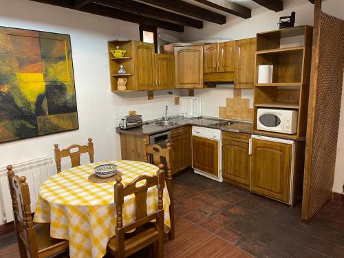 a small kitchen with a table and a microwave at Casa independiente y completa con una habitación "Venta de Cidones" in Cidones