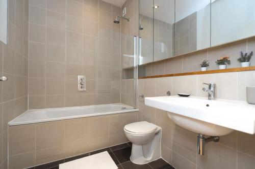 uma casa de banho com um lavatório, um WC e uma banheira em Award Winning 2 Bedroom House, King's Cross em Londres