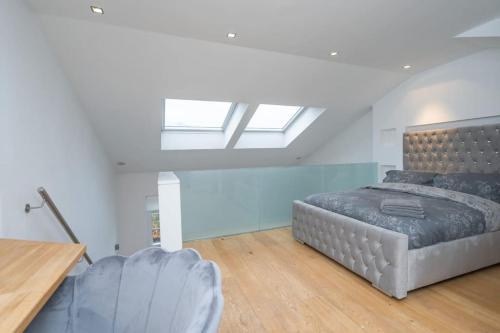 um quarto com uma cama e uma clarabóia em Award Winning 2 Bedroom House, King's Cross em Londres