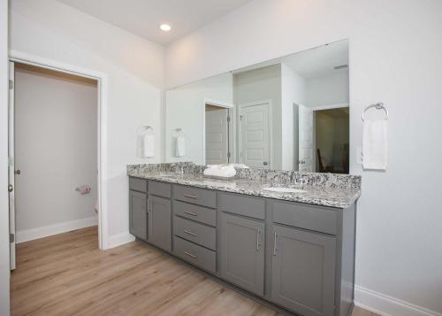 a bathroom with a sink and a large mirror at Sweet Escapes House in Foley