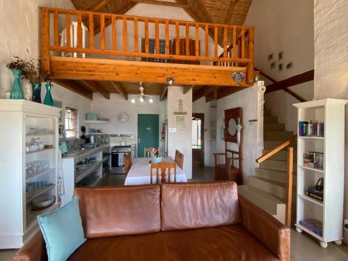 a living room with a couch and a staircase at Shalom in Paternoster