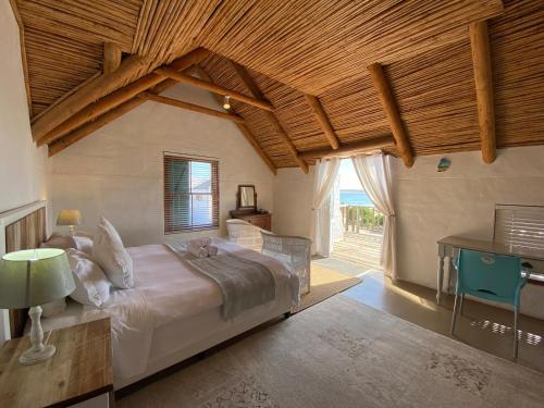 1 dormitorio con 1 cama grande y techo de madera en Shalom en Paternoster