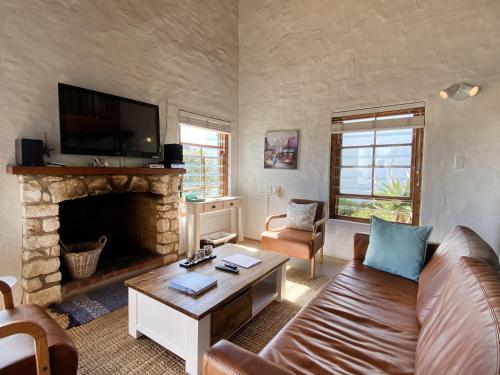 a living room with a couch and a fireplace at Shalom in Paternoster