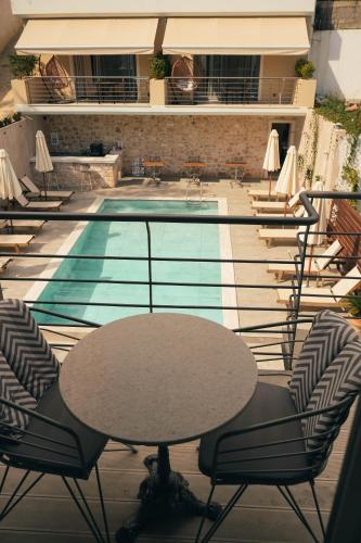 a table and chairs in front of a swimming pool at Liberte Maisonettes in Parga