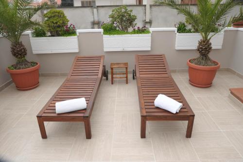 two benches with white pillows sitting on a patio at Mediterranea Sea House in Montesilvano