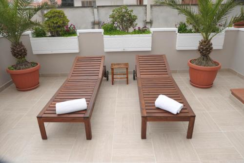 2 bancs avec des oreillers blancs installés sur une terrasse dans l'établissement B&B Mediterranea Sea House, à Montesilvano
