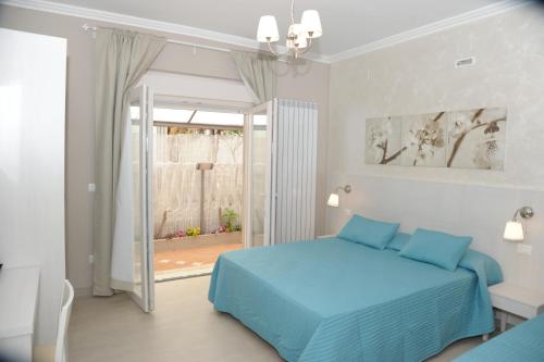 a bedroom with a blue bed and a sliding glass door at Mediterranea Sea House in Montesilvano