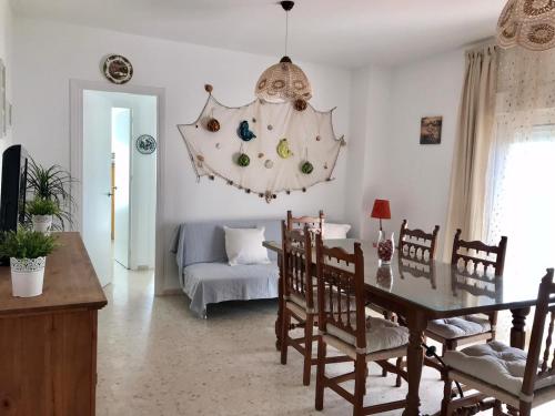 a dining room with a table and a couch at APARTAMENTO VISTAS AL MAR - Valdelagrana Playa in El Puerto de Santa María