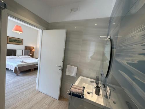 ein Badezimmer mit Dusche, Waschbecken und Bett in der Unterkunft Domus Luca - Central Rooms in the Heart of Naples in Neapel