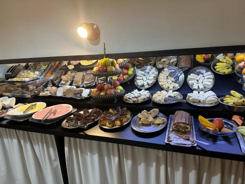 a buffet line with many different types of food at Tobaccos Palace Hotel in Santa Cruz do Sul