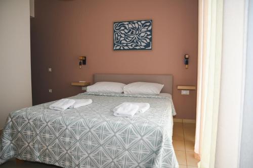a bedroom with a bed with two towels on it at Nomia apartment in Agios Nikolaos