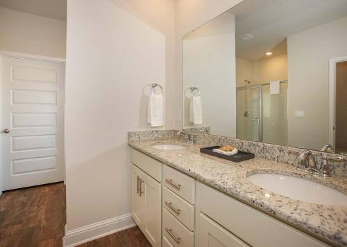 a bathroom with two sinks and a large mirror at Luxury Getaway House in Foley