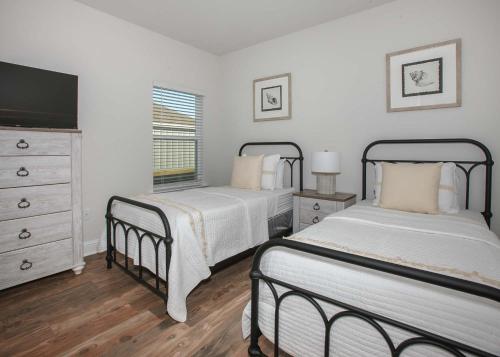 sypialnia z 2 łóżkami, telewizorem i komodą w obiekcie Luxury Getaway House w mieście Foley