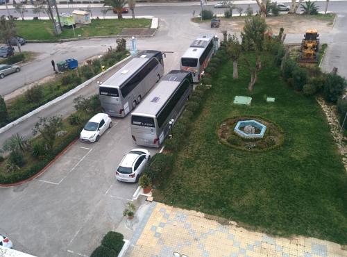 a group of buses parked in a parking lot at Delfini Hotel in Patra